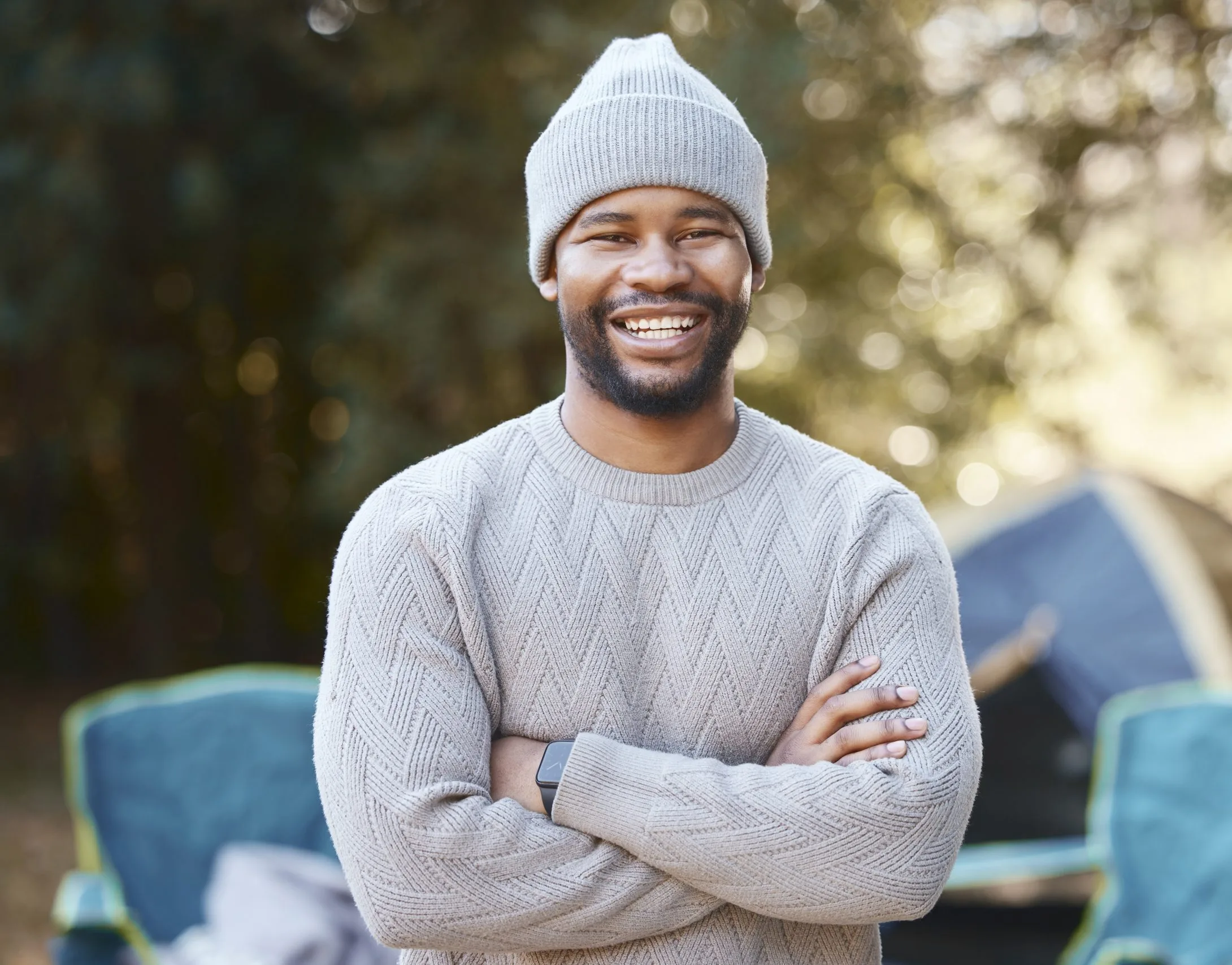 Smiling man with arms crossed in a living room